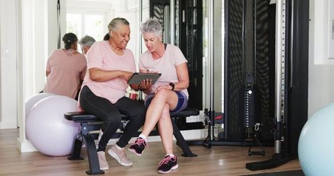 Senior Women Enjoying Fitness with Technology at Home Gym