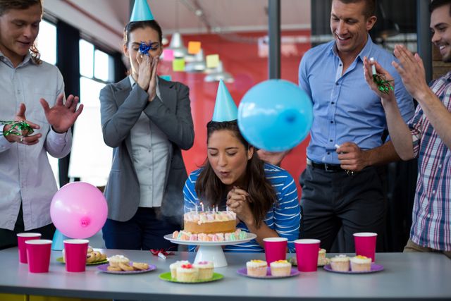 Businesspeople celebrating their colleagues birthday in office
