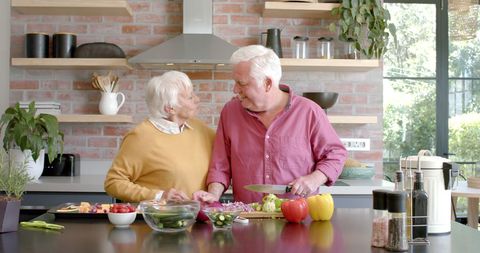 Happy Senior Couple Preparing Meal in Modern Kitchen