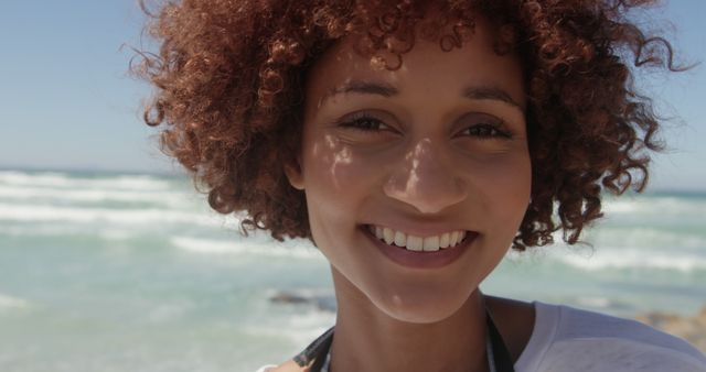 Happy biracial woman face close up on sunny beach. Feminity, summer, vacations and free time, unaltered.