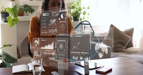 Businesswoman analyzing holographic data in modern workspace