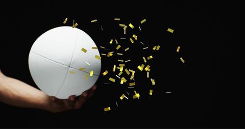 White rugby ball with gold confetti celebrating victory