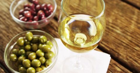 Glass of White Wine with Green Olives and Cranberries - Download Free Stock Images Pikwizard.com