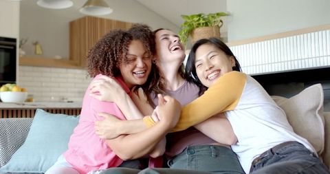 Diverse Friends Laughing and Connecting on Sofa at Home