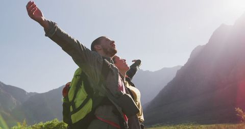 Couple Hiking in Mountains Celebrating with Open Arms