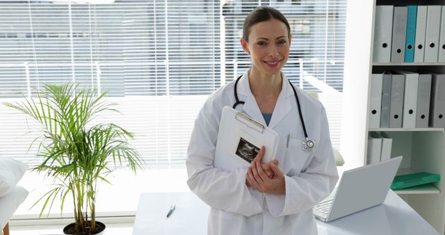 Smiling Female Doctor Holding Patient's X-Ray in Modern Office - Download Free Stock Images Pikwizard.com