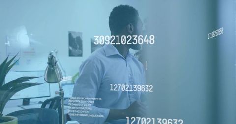 Scanning numeric data on glass partition in modern open-plan office, focused professional