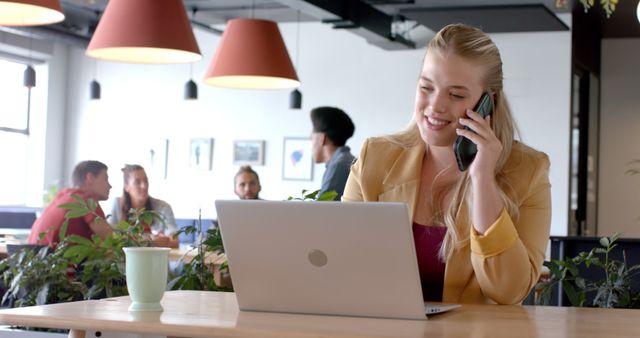 Businesswoman Talking on Phone in Modern Office with Colleagues - Download Free Stock Images Pikwizard.com