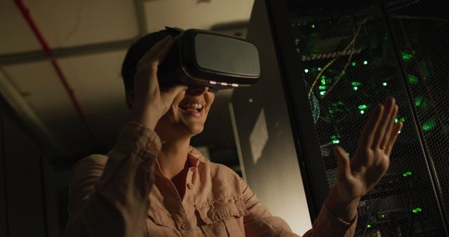 Woman in data center using VR headset, showcasing modern technology and interactive possibilities. Useful for technology, innovation, futuristic explorations, and professional tech environment contexts.