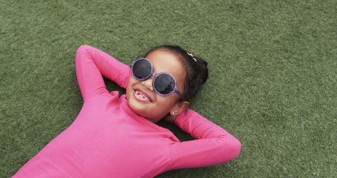Joyful Child Relaxing on Green Grass in Sunglasses