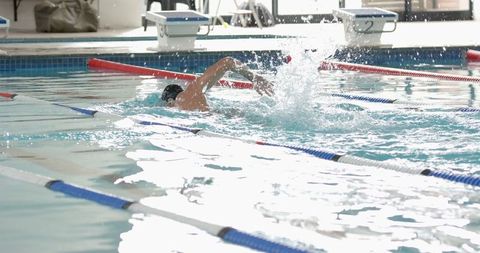 Male Athlete Practicing Freestyle Stroke in Indoor Swimming Pool