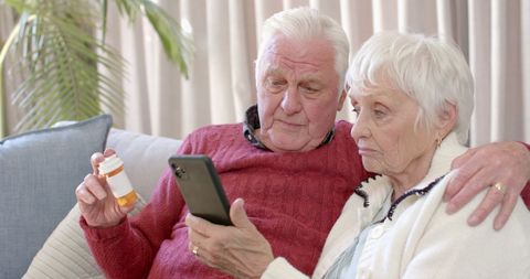 Elderly Couple Consulting Doctor Online Using Smartphone at Home