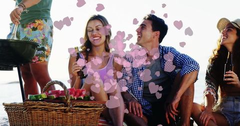 Friends Relaxing Beachside with Picnic and Grill in Summer