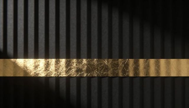 Minimalist gold foil stripe reflecting light on dark ribbed panel for luxury background