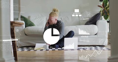 Remote freelancer working on living room rug with laptop, phone call and data analytics