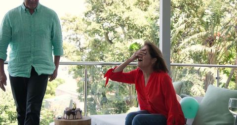 Senior couple celebrating birthday on sunlit patio