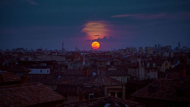 Moody Urban Rooftops with Dramatic Orange Moon