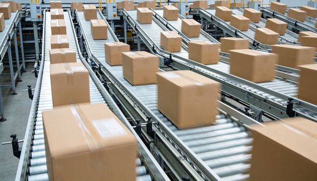 High-speed warehouse conveyors moving corrugated boxes for automated logistics and sorting