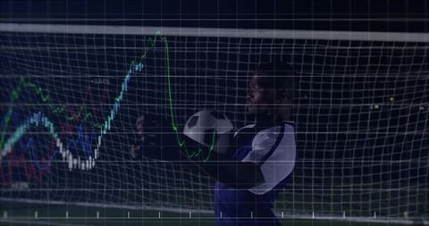 Goalkeeper balancing soccer and technology in night game