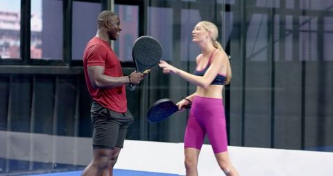 Athletic Partners Engaging in Energetic Conversation on Padel Court
