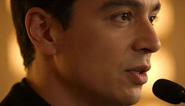 Closeup male presenter speaking into microphone presenting at conference warm bokeh