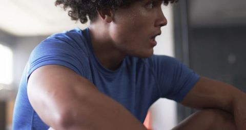 Young Man Resting During High-Intensity Workout Session in Gym
