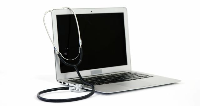 A stethoscope is draped over an open laptop, symbolizing telemedicine or online healthcare services, with copy space. It represents the integration of technology in healthcare, allowing for remote medical consultations and diagnostics.