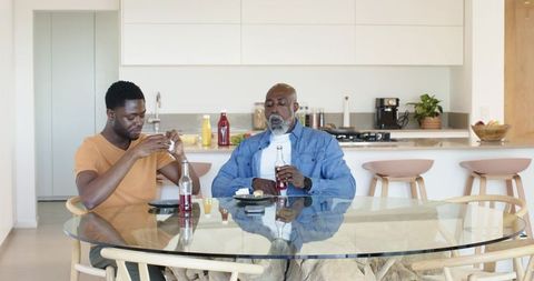 Father and Son Enjoying Drinks at Modern Kitchen Table