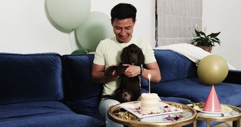 Joyful birthday celebration for man and puppy in cozy living room