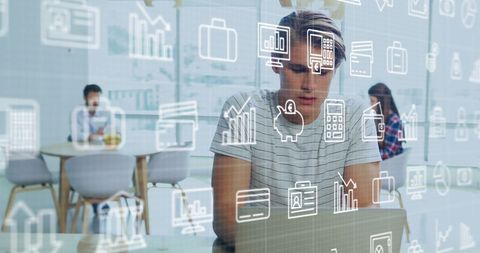 Colleagues using digital interface with business icons overlay in modern office