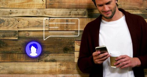 Man checking smartphone holding coffee cup by rustic wood wall with chat bubble minimalist