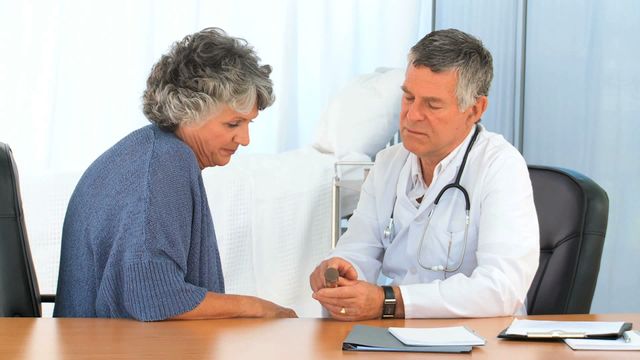 Doctor provides medication and guidance to elderly patient. Useful for healthcare, medical consultations, elderly care content.