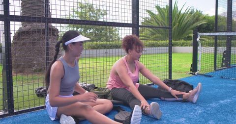 African american women stretching on blue padel court preparing for match warmup outdoor