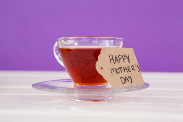 Happy mothers day card with cup of herbal tea on white table