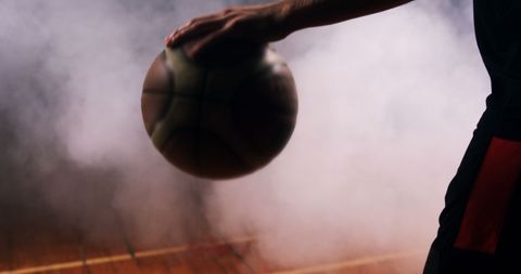Basketball Player Dribbling in Dramatic Lighting
