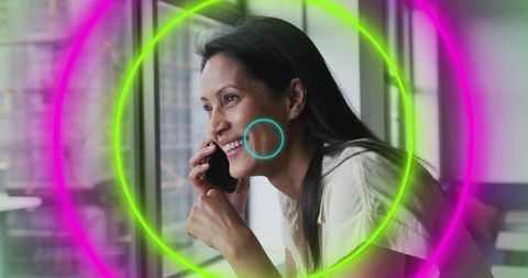 Asian Businesswoman Speaking on Smartphone with Neon Overlay by Window
