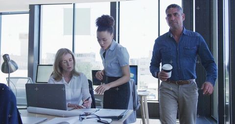 Business Team Collaborating on Blueprints in Modern Office