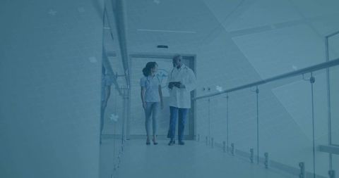 Doctor and Nurse Discussing Patient Care in Hospital Corridor