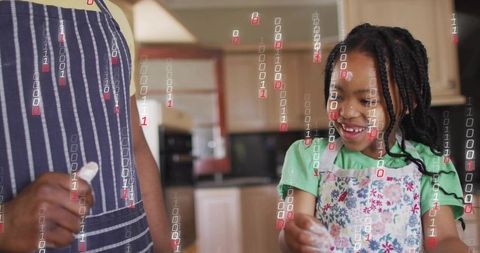 Smiling young girl mixing flour with adult in kitchen while digital binary code overlays