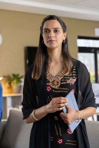 Indian businesswoman holding tablet in office wearing embroidered dress with beadwork