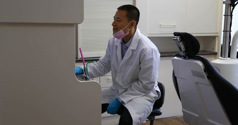 Asian Dentist Using Computer in Modern Dental Office