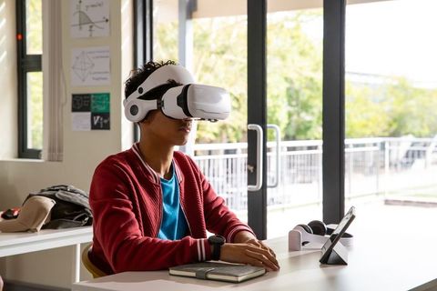 Teenager wearing virtual reality headset exploring immersive learning in bright study room