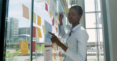 Professional Woman Planning Ideas with Sticky Notes on Glass Wall - Download Free Stock Images Pikwizard.com