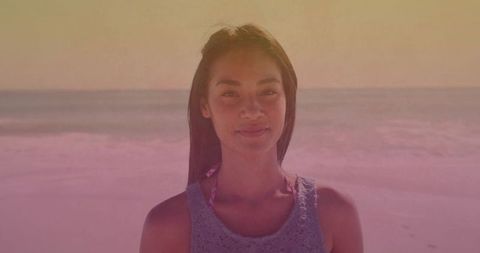 Woman enjoying tranquil sunset at beach in vibrant tones