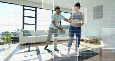 Trainer guiding pregnant woman practicing prenatal fitness in sunlit modern living room