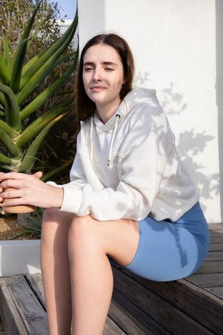 Woman enjoying gardening on sunlit porch with a peaceful smile