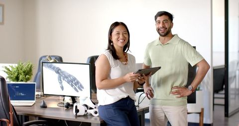 Colleagues Discussing Robotic Hand Design in Modern Office Environment