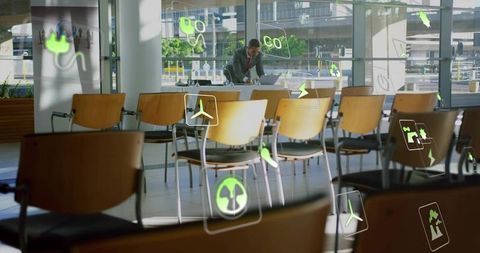 Businessman in airport lounge with futuristic energy icons