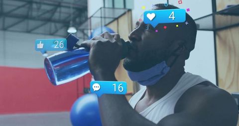 Muscular man drinking water during intense gym workout with social media notification overlays