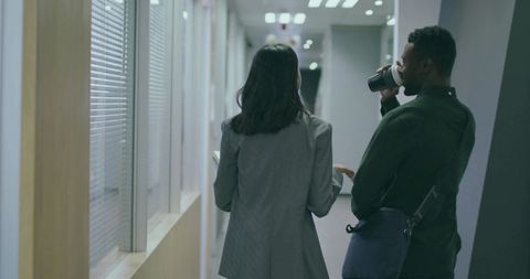 Colleagues walking and collaborating in modern office hallway